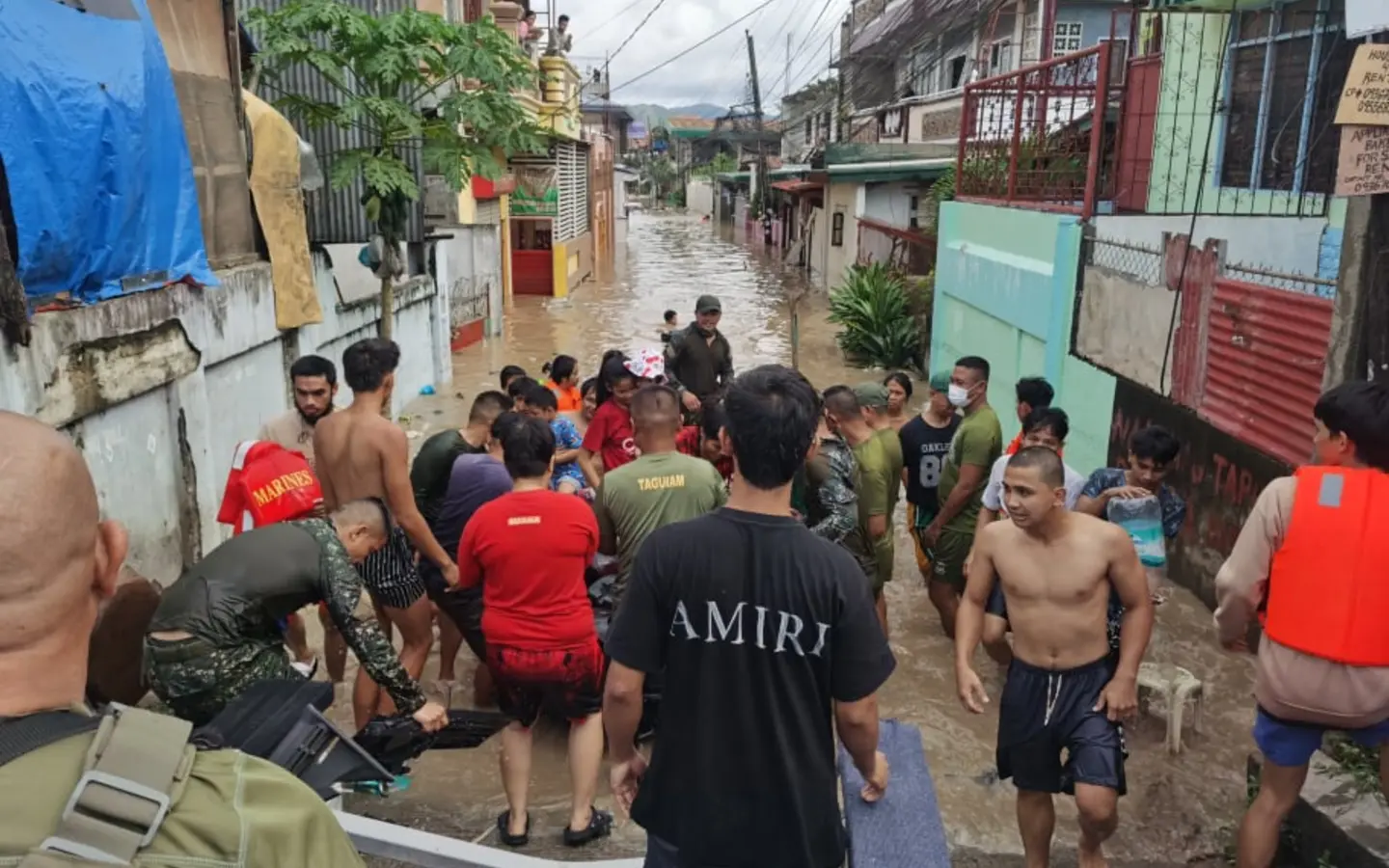 Responders and residents during a flood rescue operation in a Philippine neighborhood